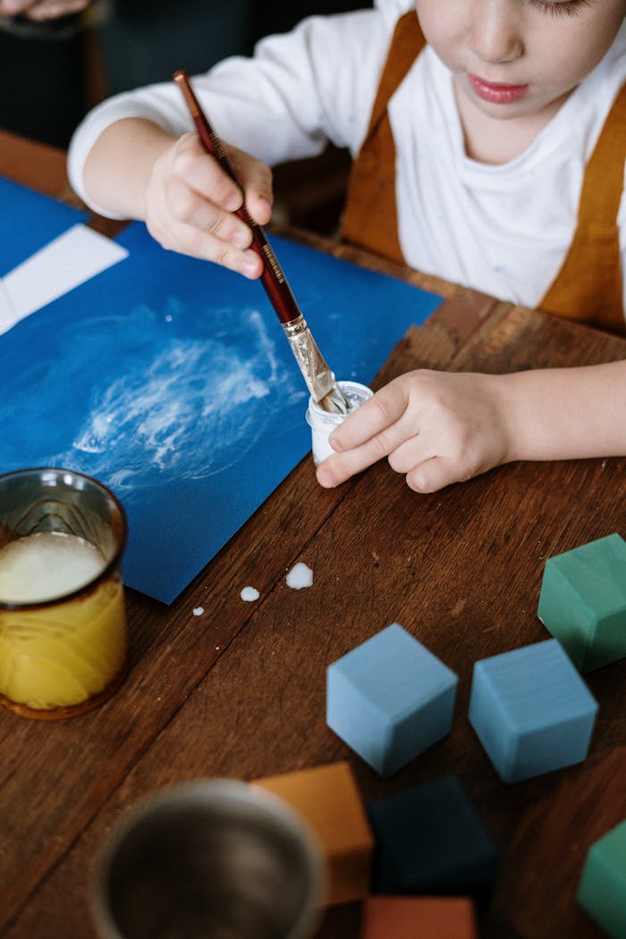 Young child painting during an art session, exploring creativity with various materials.