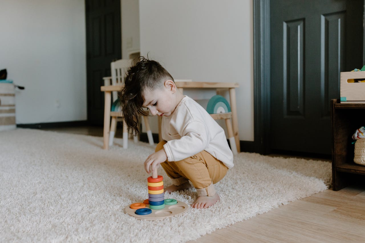Young child engaging with colorful educational toy in cozy indoor setting.